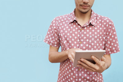 Buy stock photo Tablet, search and hands of man in studio for newsletter, sign up or elearning registration on blue background. Digital, app or gen z student online for ebook streaming, research or upskill education