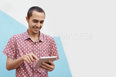 Buy stock photo Shot of a cheerful young student standing outside  and working on his tablet before class