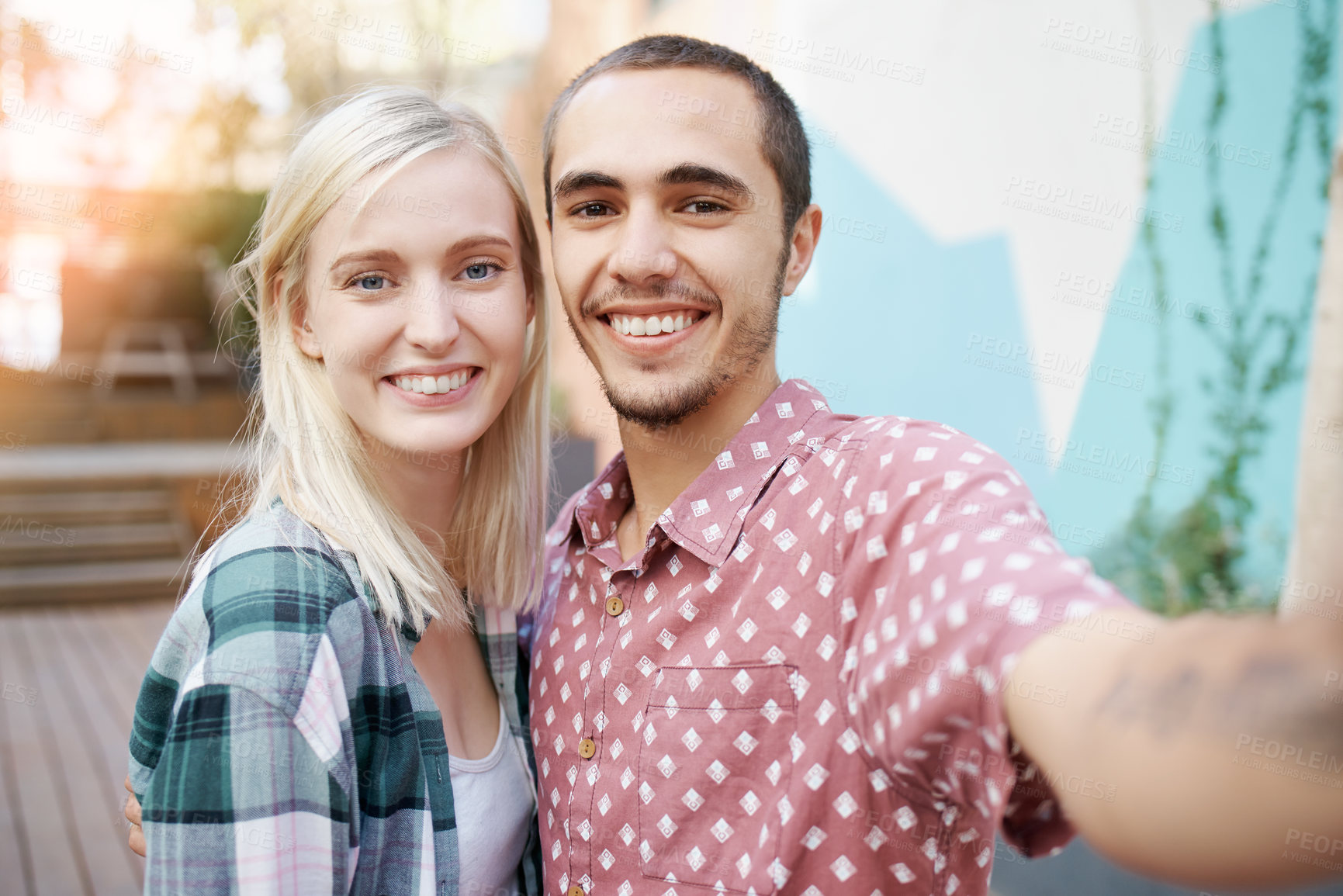 Buy stock photo Shot of a happy young couple taking selfies together outside