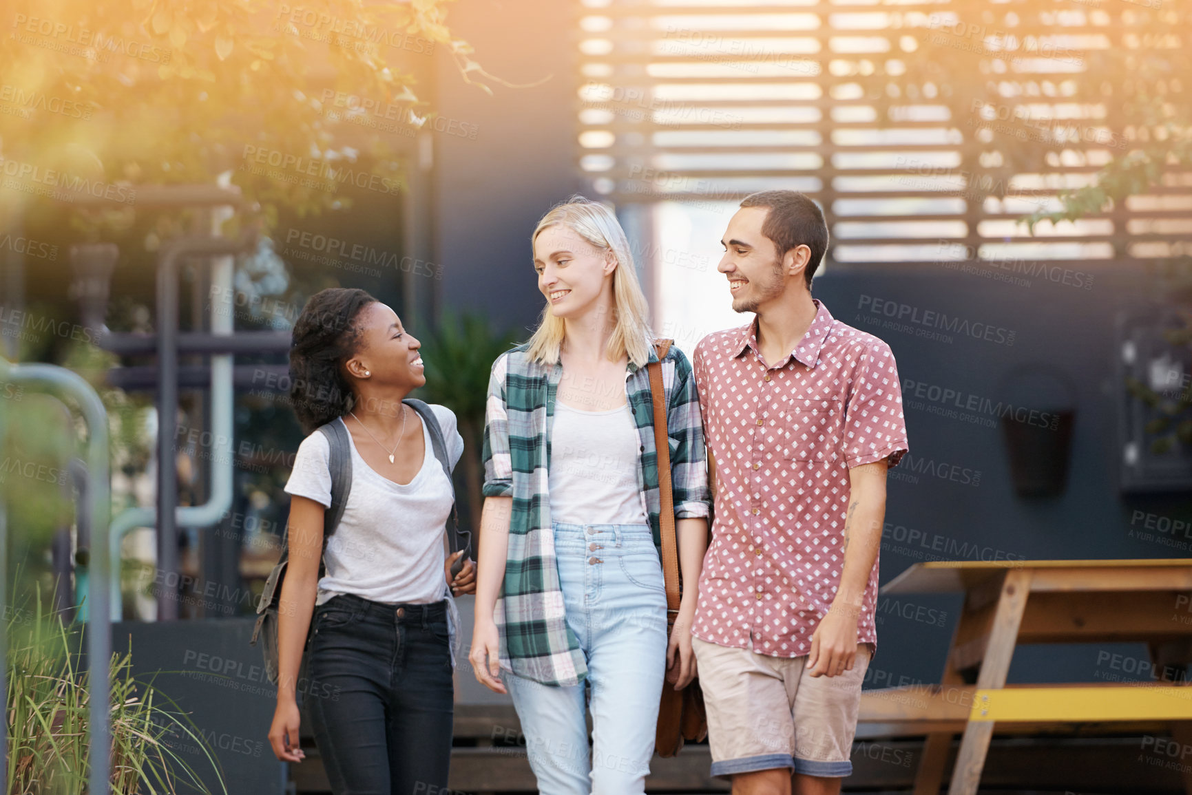 Buy stock photo Walking, diversity and students in conversation at university planning for study, assignment or test. Friends, discussion and young people with bags outdoor and talking at college campus together.