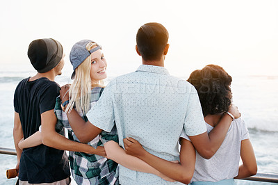 Buy stock photo Rearview shot of a group of young friends standing on the promenade