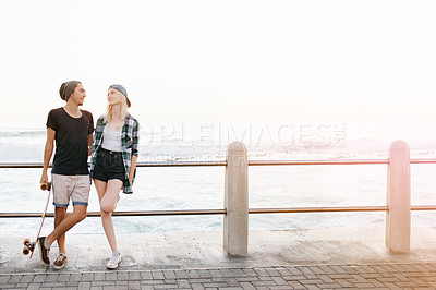 Buy stock photo Couple, love and happy with skateboard at beach in summer or hot weather, together with sunset in London. Relationship, commitment and bonding for romance with soulmate, care and smile in boardwalk