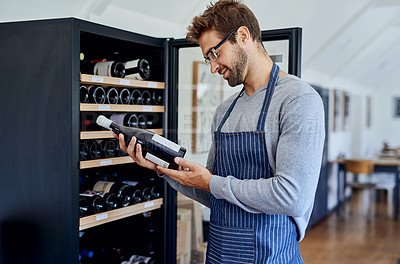 Buy stock photo Cropped shot of a handsome young sommelier working in his restaurant