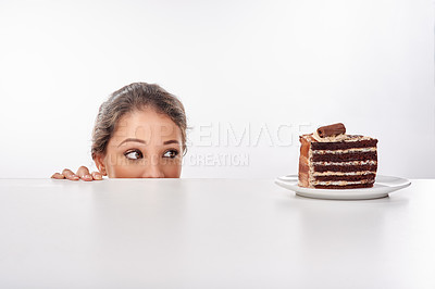Buy stock photo Studio shot of an attractive young woman being tempted by something sweet