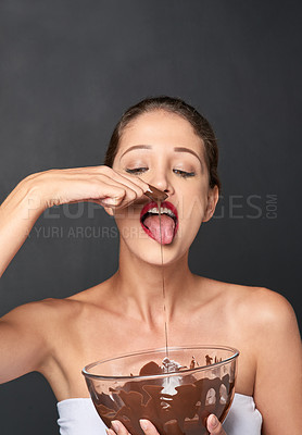 Buy stock photo Bowl, chocolate and sweets with finger of woman tasting mix in studio isolated on gray background. Candy, food and taste with confident young person eating cocoa from glass dish for baking or flavor