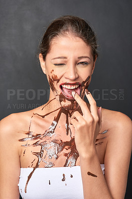 Buy stock photo Woman, studio and melted chocolate on face, beauty and cocao snack on gray background for skincare. Happy female person, messy and dessert diet for cosmetics, foundation and vegan facial treatment