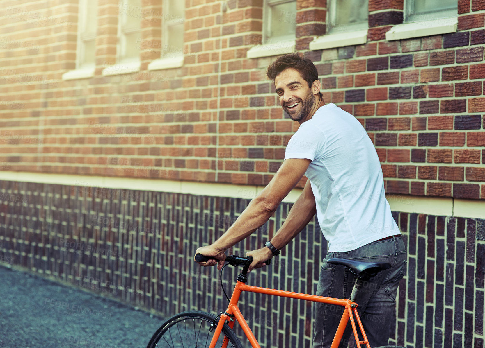 Buy stock photo Travel, bicycle and portrait of man by brick wall in city for sightseeing on vacation or adventure. Smile, walking and male person with bike in town street on weekend trip or holiday in Netherlands.