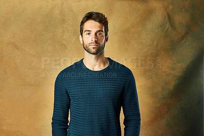 Buy stock photo Studio shot of a handsome young man posing against a golden background