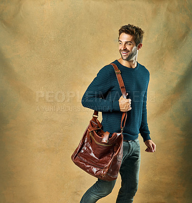 Buy stock photo Fashion, thinking and smile of man in studio with leather bag isolated on a brown background mockup space. Idea, happy and person in casual clothes, jeans and laughing for trendy style on a backdrop