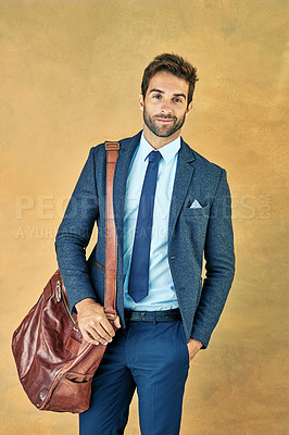 Buy stock photo Studio shot of a handsome young businessman posing against a golden background