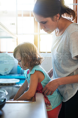 Buy stock photo Washing, dishes and mom with girl in home for chores, teaching and learning hygiene routine. Housekeeping, mother and daughter cleaning kitchen together in support, care and child development at sink