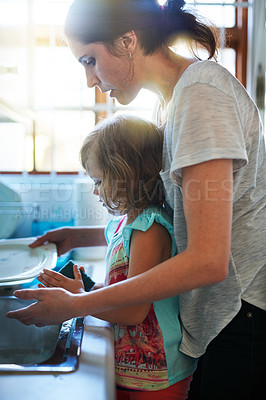 Buy stock photo Shot of a mother and daughter washing dishes together