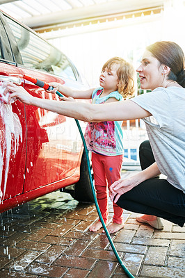 Buy stock photo Shot of a mother and daughter washing a car together