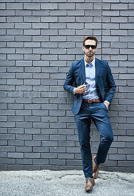 Buy stock photo Fashionable, man and wall in suit with sunglasses for fashion, style and trendy in outdoor. Male person, pride and confidence in street for work, corporate or career in men's wear in grey background