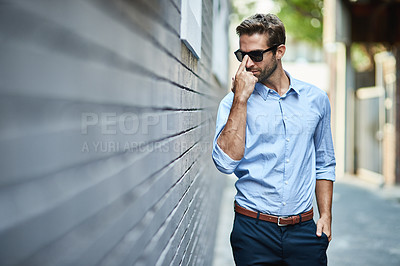 Buy stock photo Sunglasses, fashion and man by brick wall in city with trendy, stylish and classy outfit. Accessory, handsome and male person with elegant shirt and pants for style with confidence in town street.