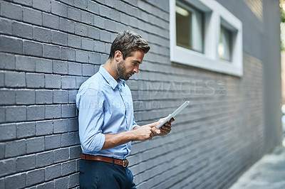 Buy stock photo Business man, tablet and research, reading email or info online on a wall in city. Serious, digital technology and professional on website, app or consultant networking on internet outdoor in town