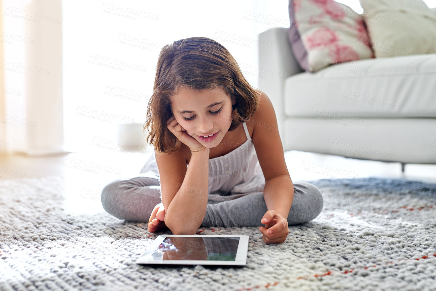 Buy stock photo Child, tablet and living room on floor at house for education by learning on digital technology. Happy, girl and reading on ebook with internet for information, knowledge and literacy for development