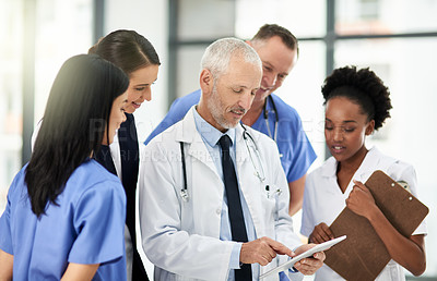 Buy stock photo Senior doctor, tablet and coaching intern in healthcare for research, teamwork or meeting at the hospital. Elderly medical professional training staff on technology in team diversity or collaboration
