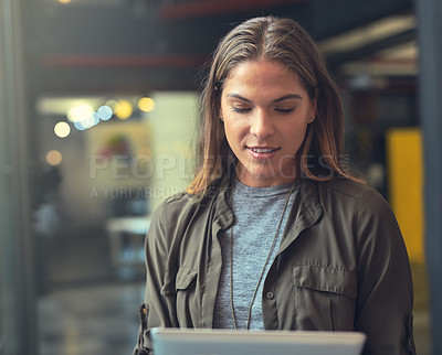 Buy stock photo Shot of a young woman using a tablet indoors 
