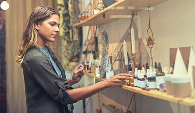 Buy stock photo Shot of a young woman looking at products in a store