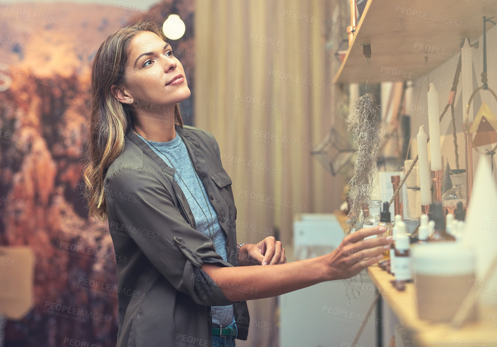 Buy stock photo Shot of a young woman looking at products in a store