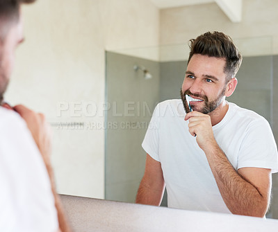Buy stock photo Cropped shot of a handsome young man going through is morning routine in the bathroom