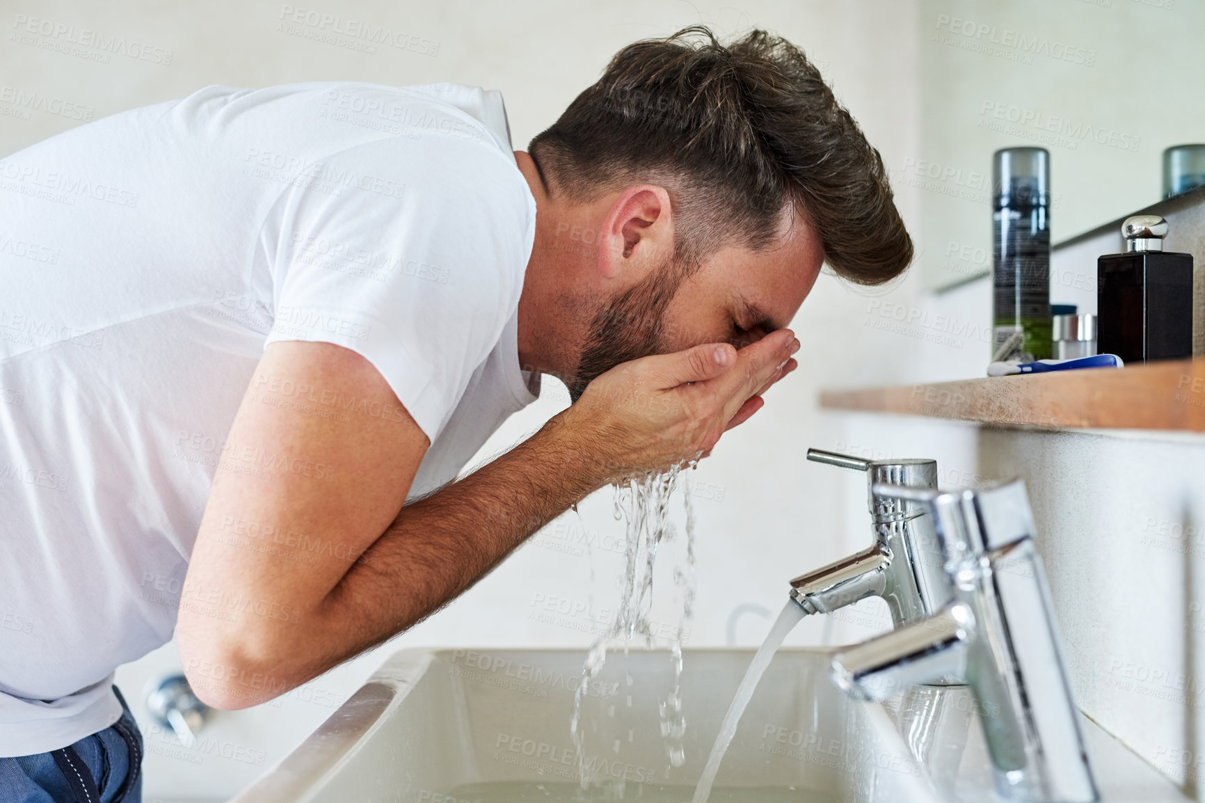 Buy stock photo Cropped shot of a handsome young man going through is morning routine in the bathroom