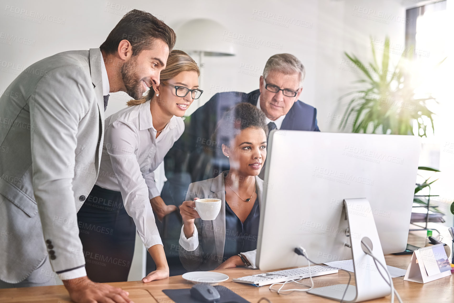 Buy stock photo Shot of businesspeople working together on a computer in an office