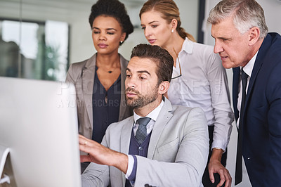 Buy stock photo Shot of businesspeople working together on a computer in an office