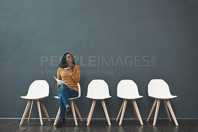 Buy stock photo Shot of a young woman yawning while waiting in line for a job interview