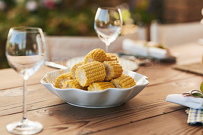 Buy stock photo Corn, food and table set for lunch outdoors with wine glasses. Fine dining, champagne glasses and delicious healthy maize in bowl for brunch party, buffet or celebration with luxury meal outside.
