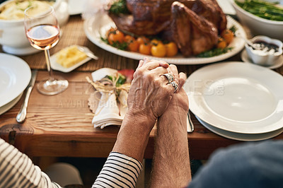 Buy stock photo Hands, pray and food with a senior couple sitting at a dining room table for a roast lunch together. Prayer, grace and holding hands with a mature man and woman eating, bonding or enjoying a meal