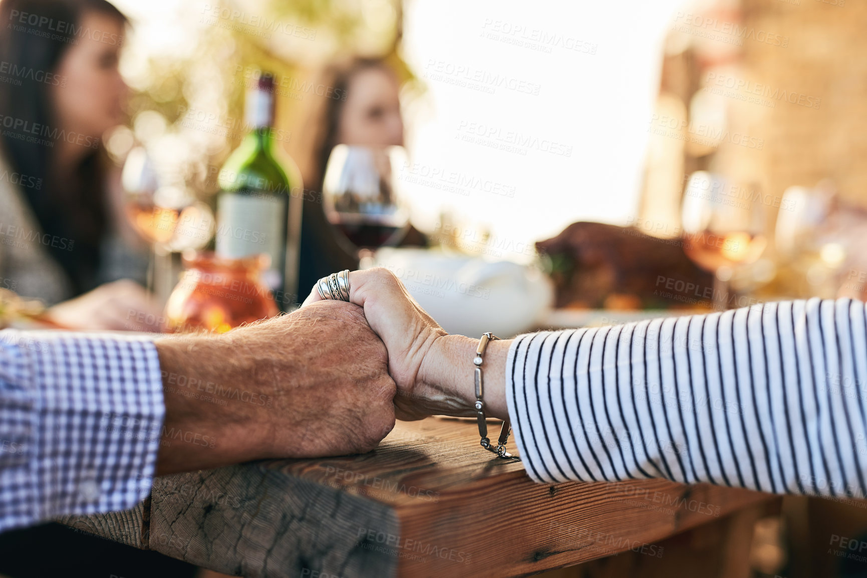 Buy stock photo Hands, pray and party with a senior couple sitting at a dinner day with their family for a celebration. Holding hands, love and prayer with a mature man and woman enjoying a meal together in a home