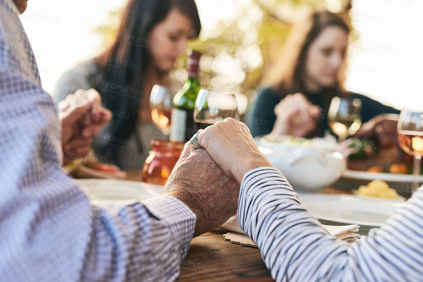 Buy stock photo Family, prayer and lunch for thanksgiving, celebration or party in garden, backyard or outdoor restaurant. Holding hands, mindfulness and gratitude for worship, god and praying with food on table