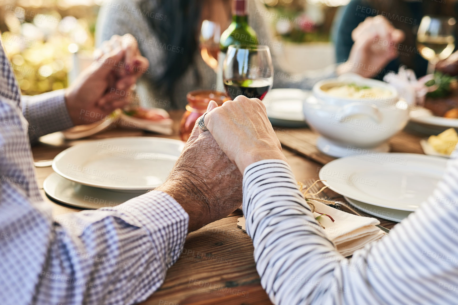 Buy stock photo Dinner, holding hands and family prayer at table for thanksgiving celebration with faith, religion and holiday gratitude. Love, social and hand holding of people praying for party, food and wine