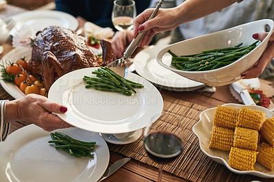 Buy stock photo Hands, food and family at a table for thanksgiving, eating and bond on vacation, sharing a meal in their home together. Hand, vegetable and host serving woman during lunch, feast and gathering