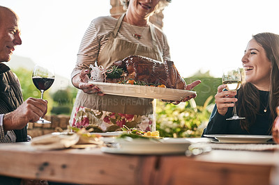 Buy stock photo Thanksgiving, food and family with a woman carrying a turkey during a dinner party outdoor for celebration. Christmas, eating and tradition with a man and woman group enjoying chicken together