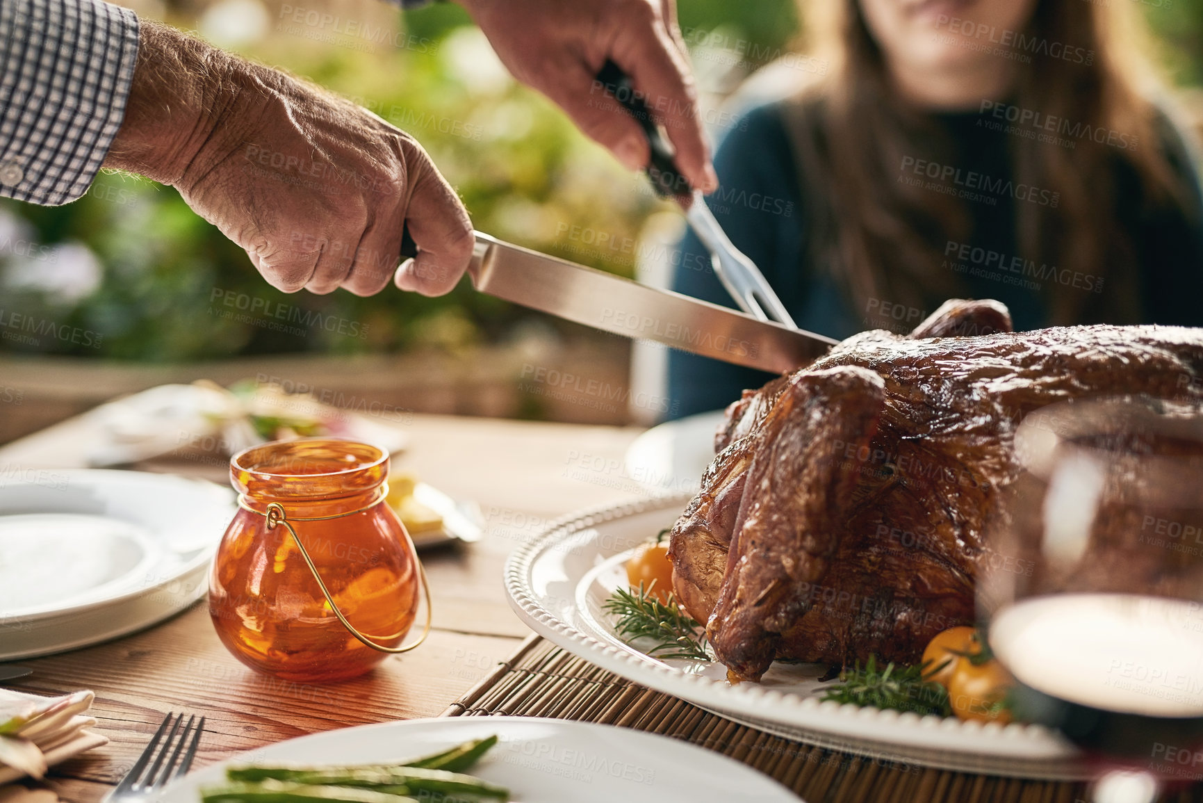 Buy stock photo Food, hands and turkey with family at a table in celebration of thanksgiving, tradition and lunch meal on a patio. Chicken, hand and man carving meat to share with friends at christmas party outdoor