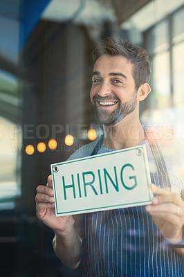 Buy stock photo Man with hiring sign, cafe window with recruitment and job opportunity, happy waiter or barista in portrait. Small business, entrepreneur and male owner onboarding, advertising hire at coffee shop