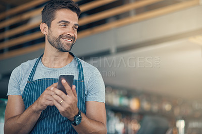 Buy stock photo Shot of a young man using a mobile phone while working at a coffee shop