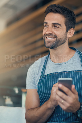 Buy stock photo Shot of a young man using a mobile phone while working at a coffee shop