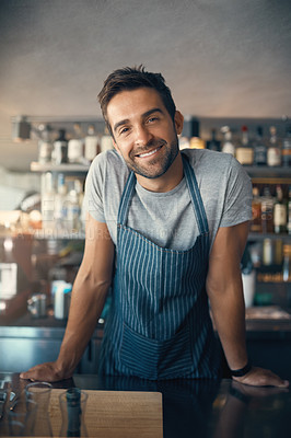 Buy stock photo Portrait of a young man working behind a bar counter