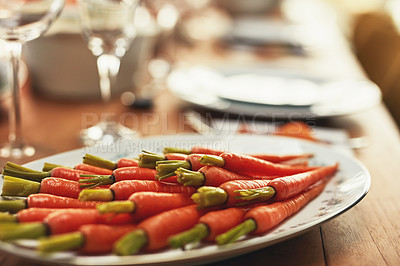 Buy stock photo Thanksgiving, carrots and food with a plate of vegetables on a dinner table for tradition in an empty room. Roast, meal and nutrition with a lunch serving on a wooden surface in a house or home