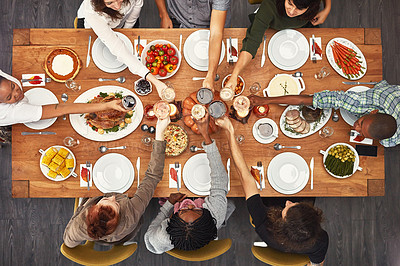 Buy stock photo Shot of a group of people sitting together at a dining table ready to eat