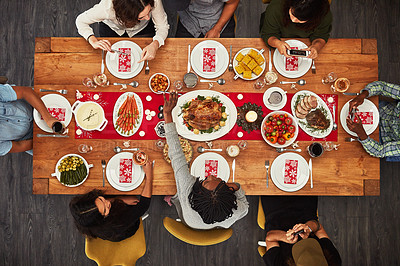 Buy stock photo Thanksgiving, overhead and friends sitting around a table for a food meal during a celebration event. Family, roast or nutrition with a man and woman group in the living room for a social gathering