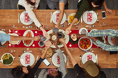 Buy stock photo Cropped shot of a group of people making a toast at a dining table