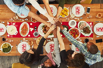 Buy stock photo Christmas, high five and food with a group of friends sitting around a dinner table together for celebration. Thanksgiving, hands and meal with a team enjoying a lunch on a wooden surface from above