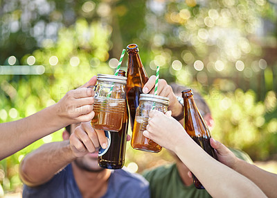 Buy stock photo Cropped shot of a young group of friends toasting while enjoying a few drinks outside in the summer sun