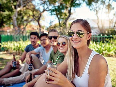 Buy stock photo Cropped portrait of an attractive young woman enjoying a few drinks with friends outside in the summer sun
