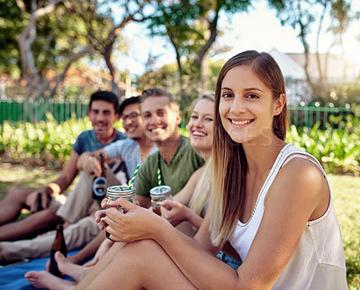 Buy stock photo Cropped portrait of an attractive young woman enjoying a few drinks with friends outside in the summer sun
